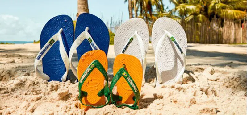 Selection of colourful Womens Havaiana flip flops in the sand